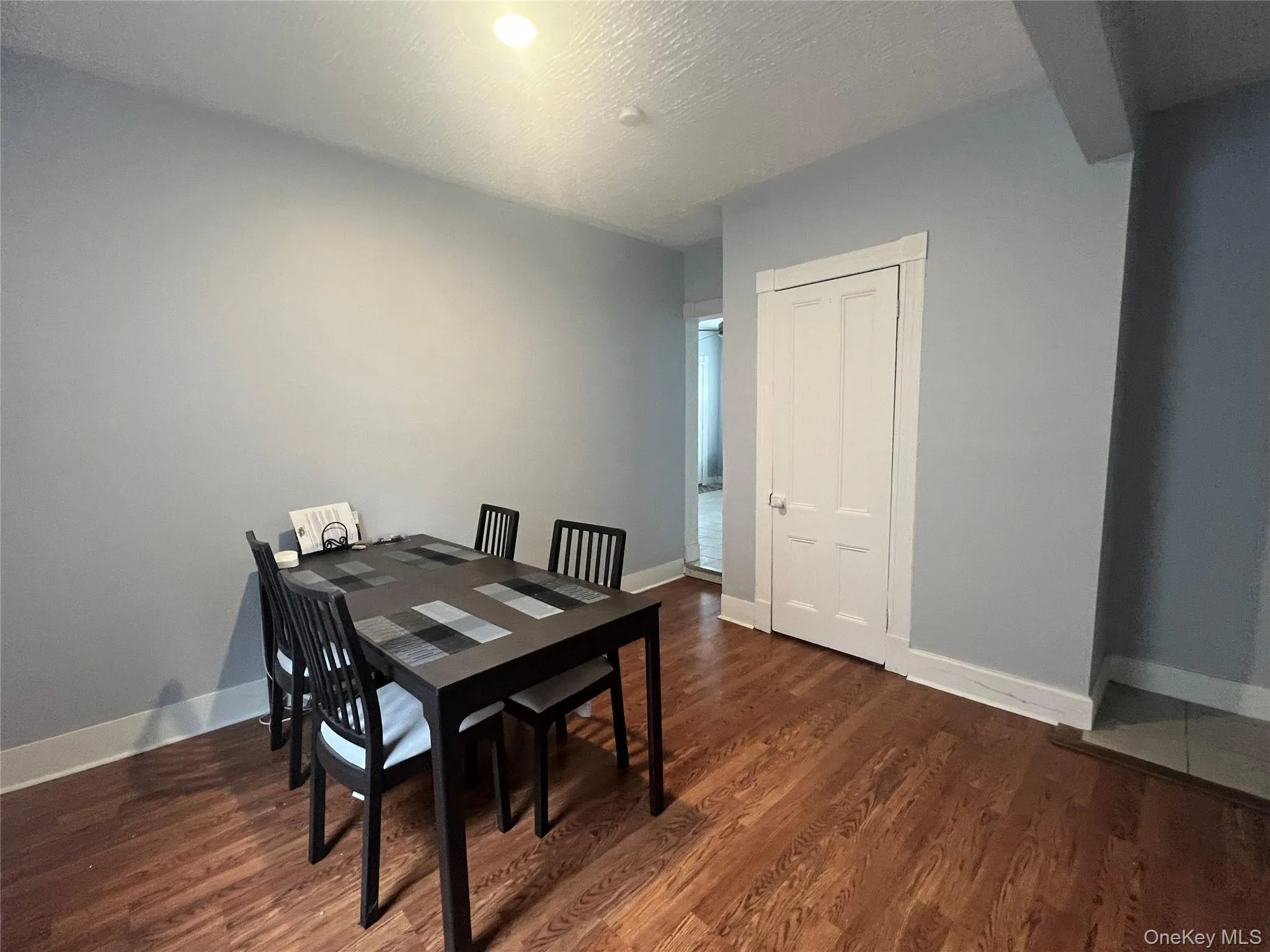 Dining area with dark wood-style floors and a textured ceiling Dining area with dark wood-style floors and a textured ceiling