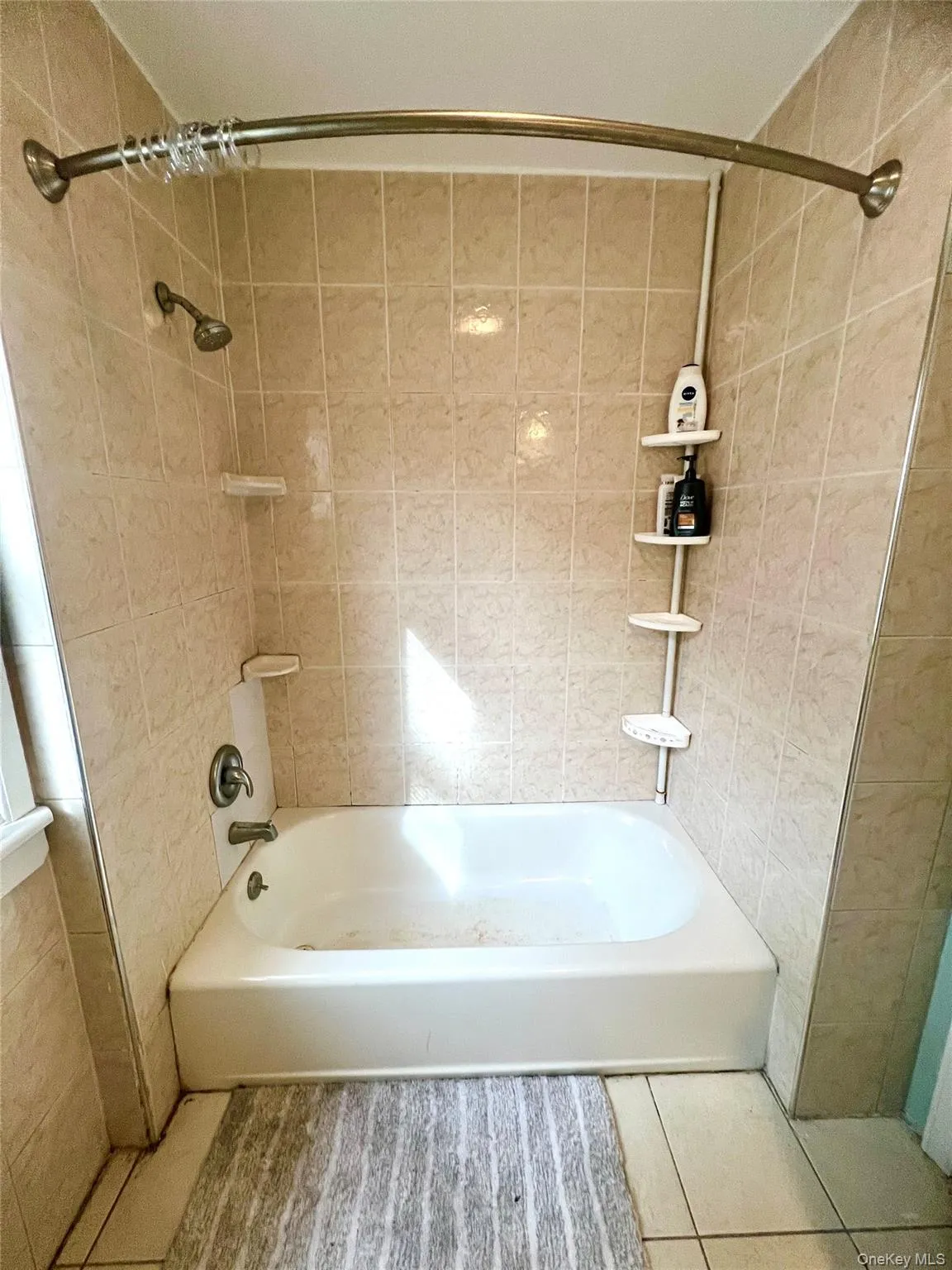 Bathroom with tub / shower combination and tile patterned flooring Bathroom with tub / shower combination and tile patterned flooring