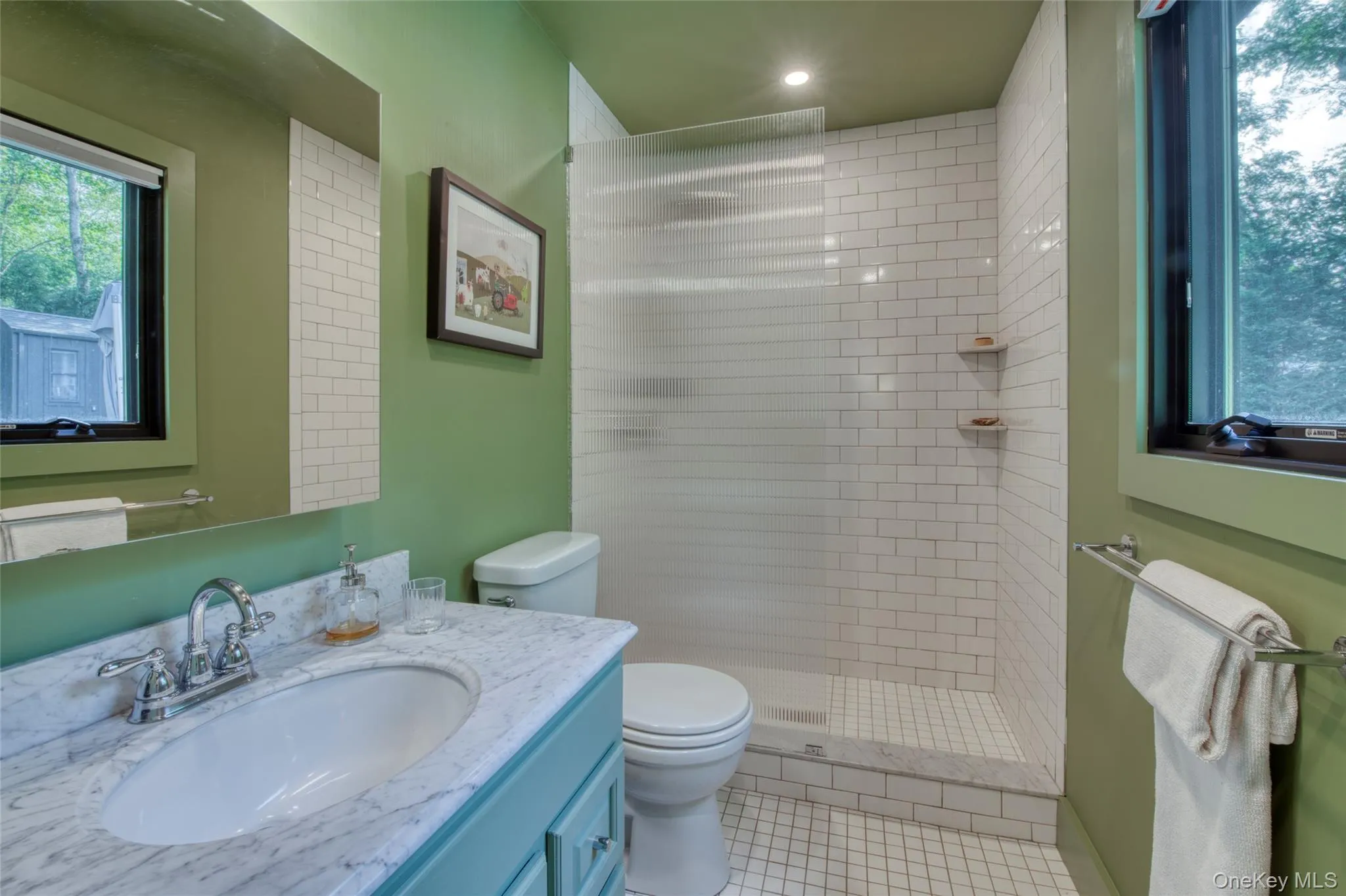 Full bath with vanity, a shower stall, and light tile patterned flooring Full bath with vanity, a shower stall, and light tile patterned flooring