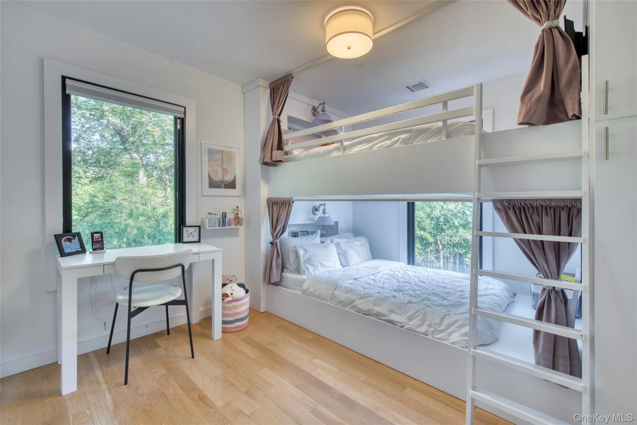 Bedroom featuring multiple windows and wood finished floors Bedroom featuring multiple windows and wood finished floors