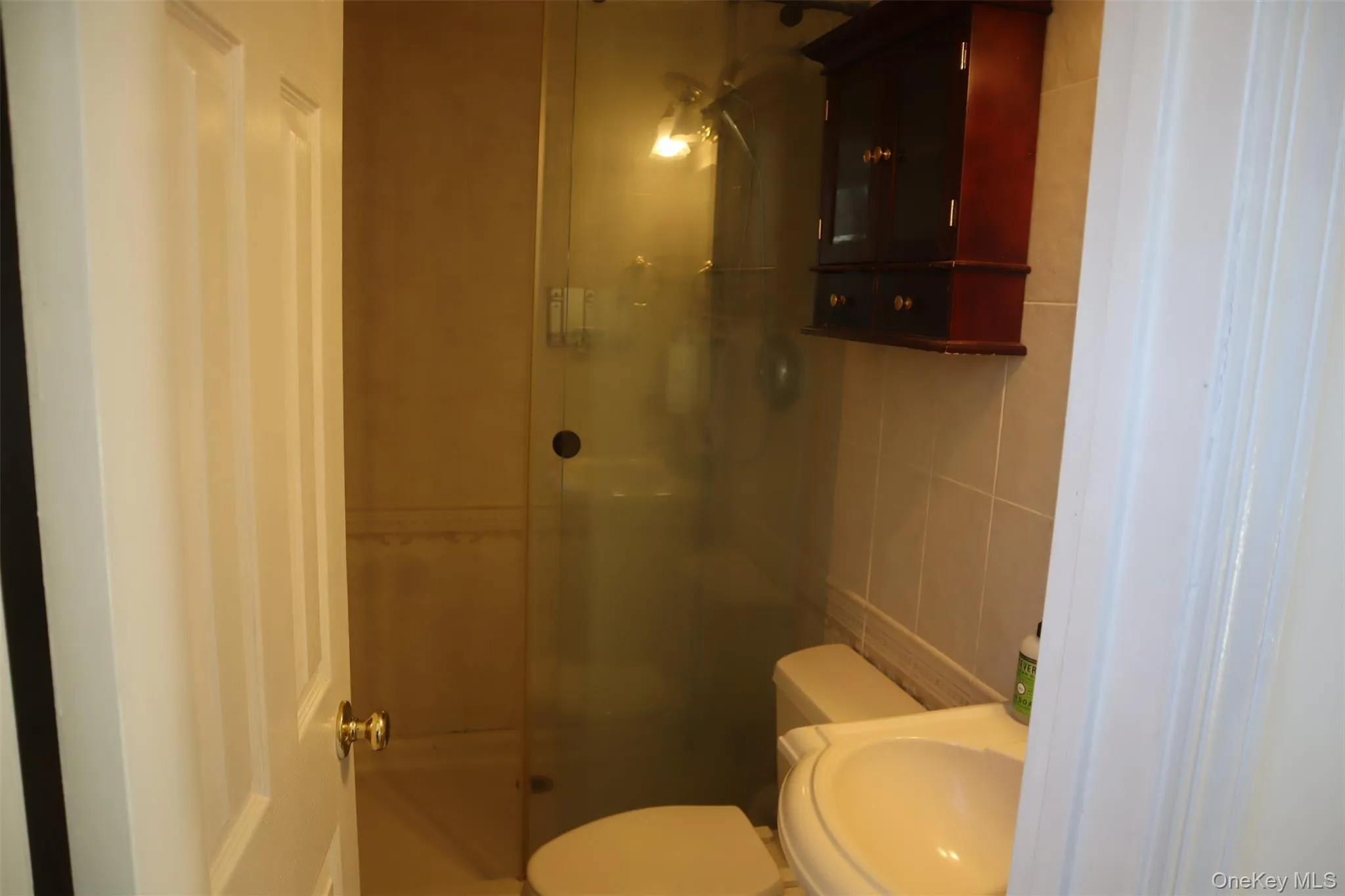 Bathroom featuring tile walls and a stall shower Bathroom featuring tile walls and a stall shower