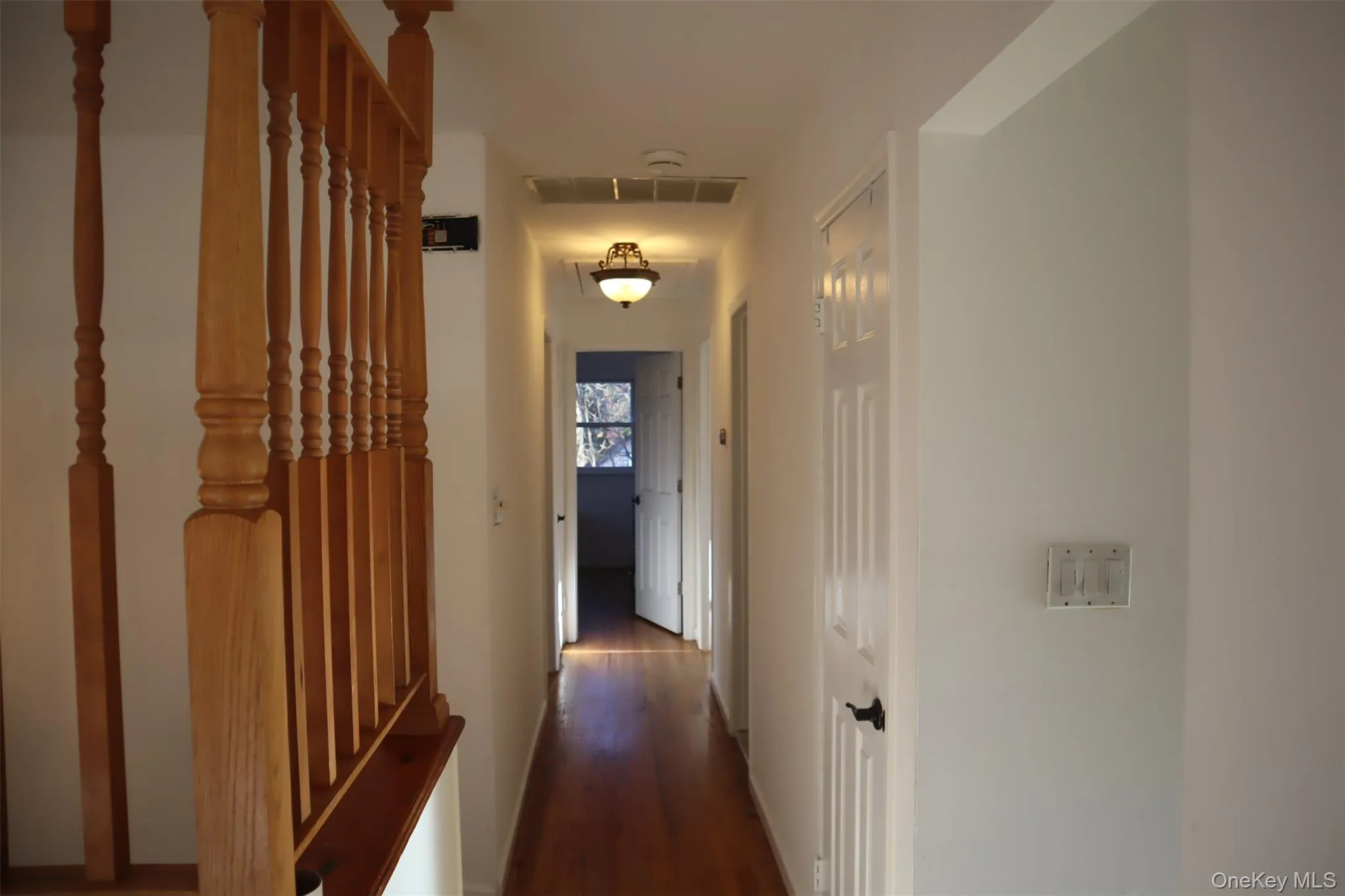 Corridor with dark wood finished floors and baseboards Corridor with dark wood finished floors and baseboards