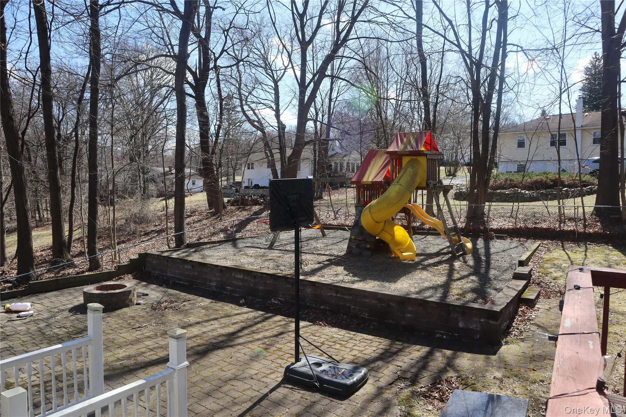 View of jungle gym with a fire pit and a patio area View of jungle gym with a fire pit and a patio area