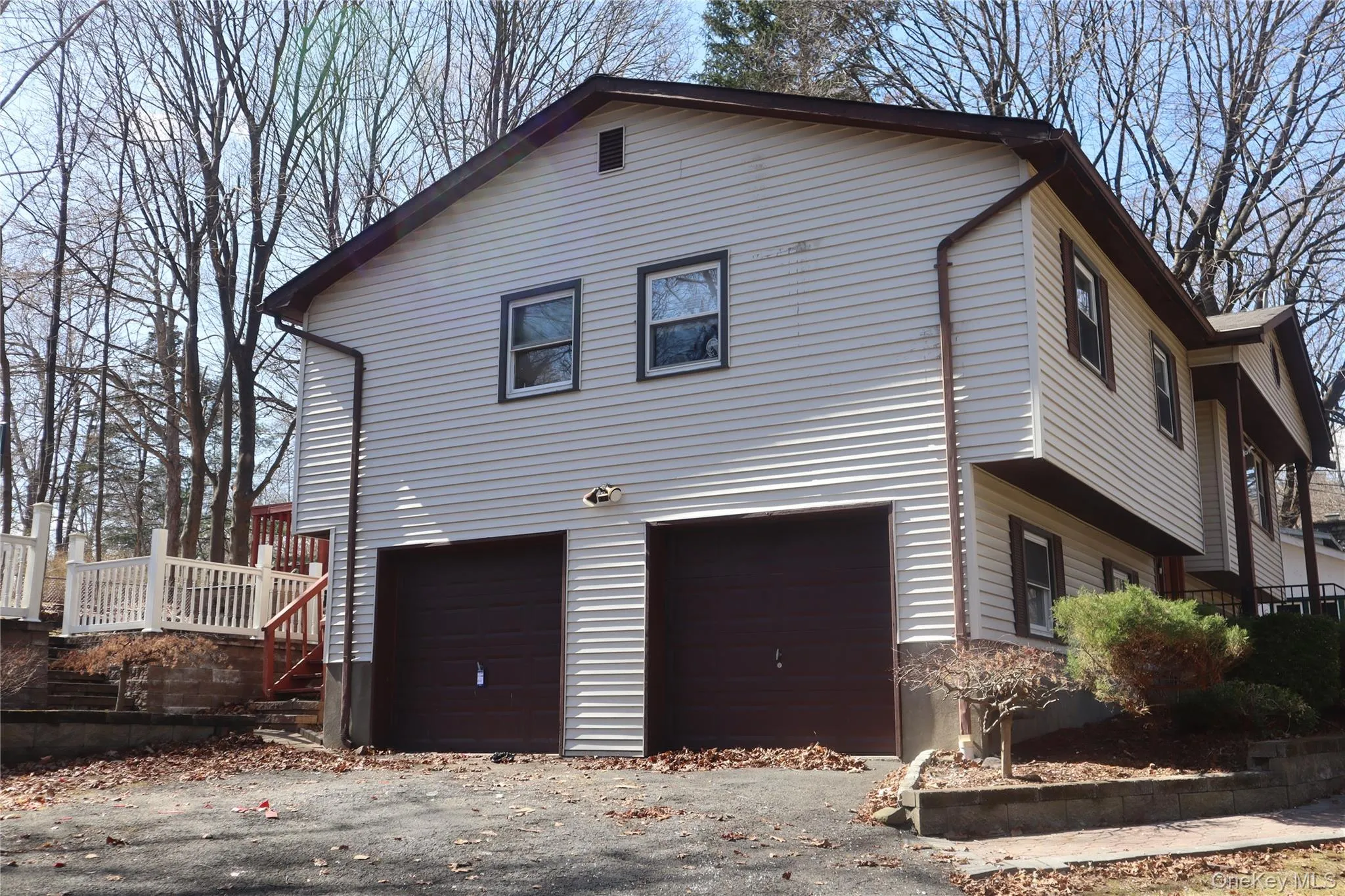 View of side of home with an attached garage, a wooden deck, and stairway View of side of home with an attached garage, a wooden deck, and stairway