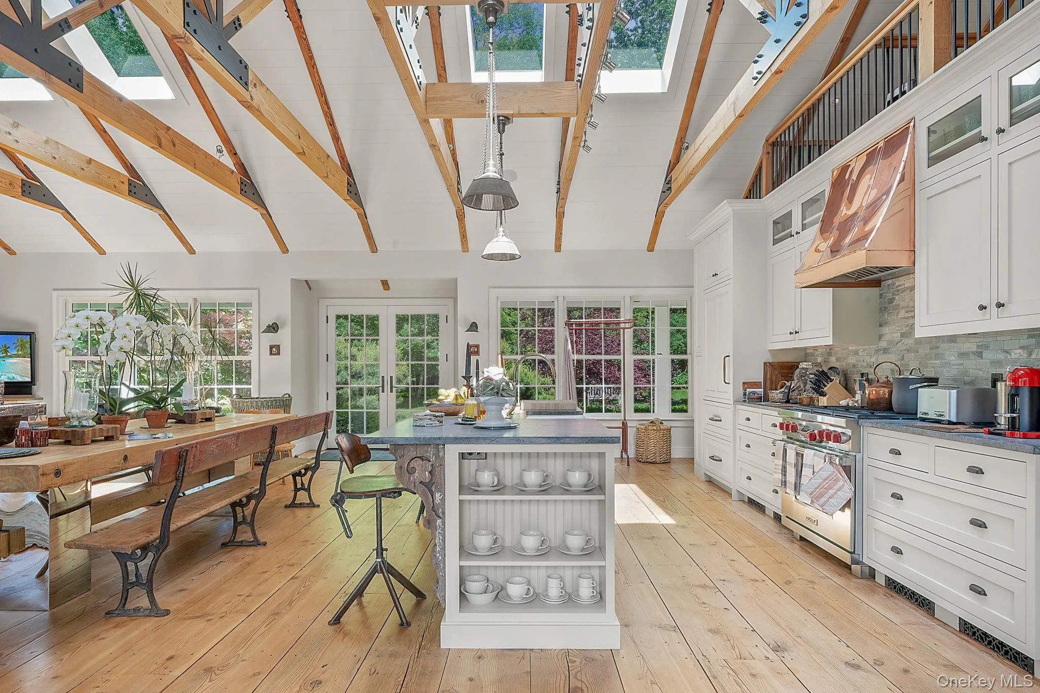 Kitchen with dark countertops, open shelves, glass insert cabinets, white cabinets, and a skylight Kitchen with dark countertops, open shelves, glass insert cabinets, white cabinets, and a skylight