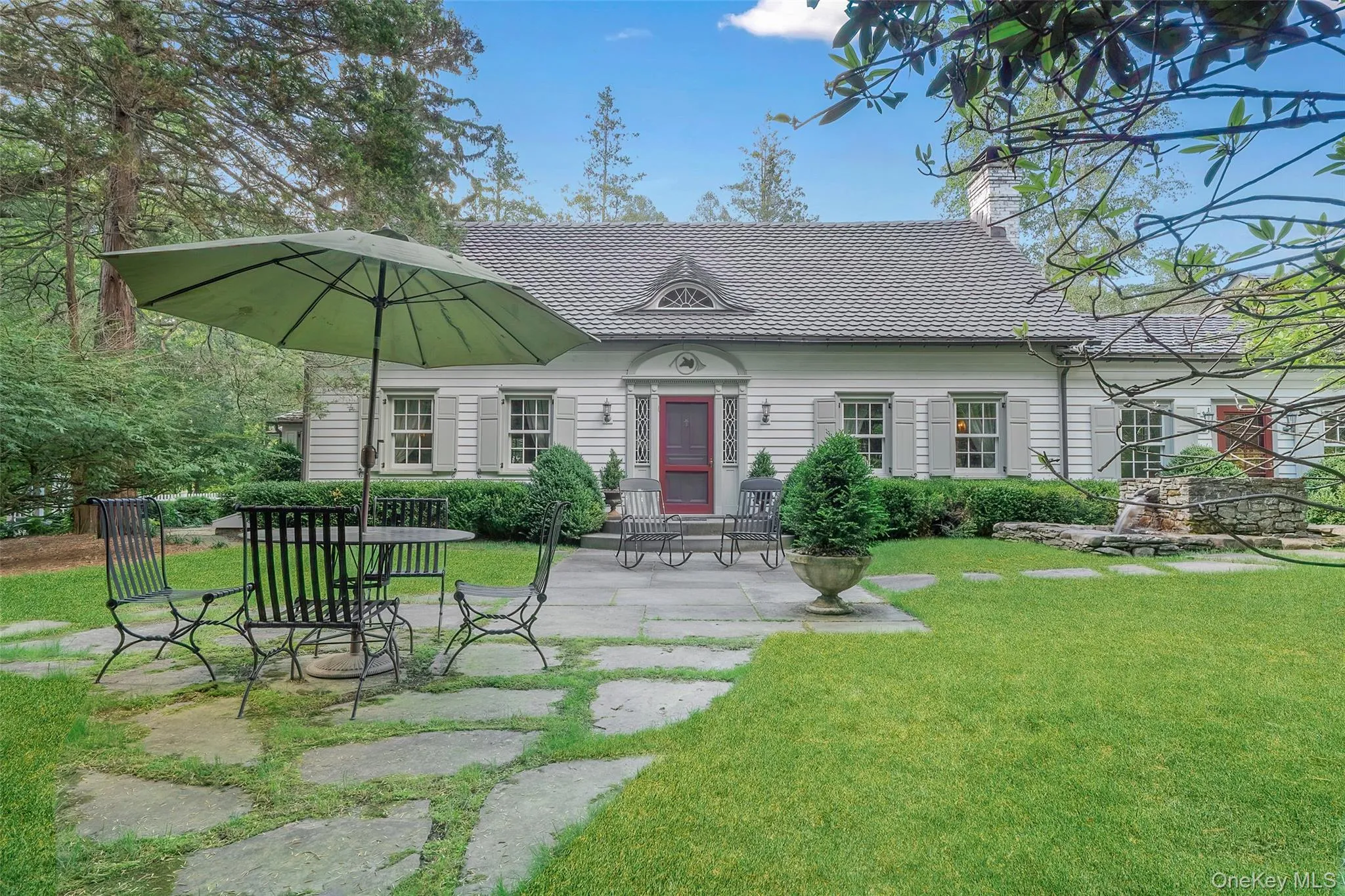 View of front of property featuring a front lawn, a chimney, and a patio View of front of property featuring a front lawn, a chimney, and a patio