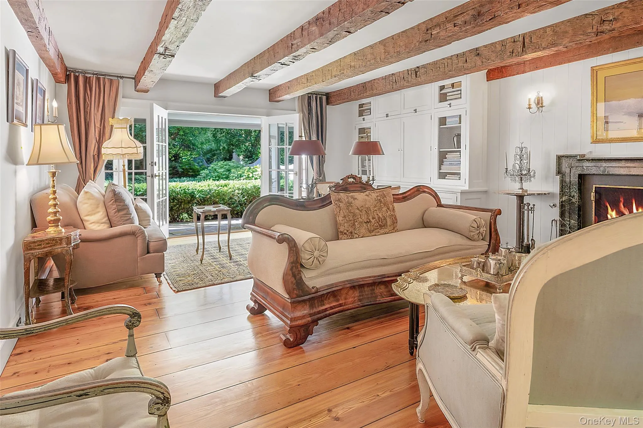 Living room with beam ceiling, a fireplace, and hardwood / wood-style flooring Living room with beam ceiling, a fireplace, and hardwood / wood-style flooring