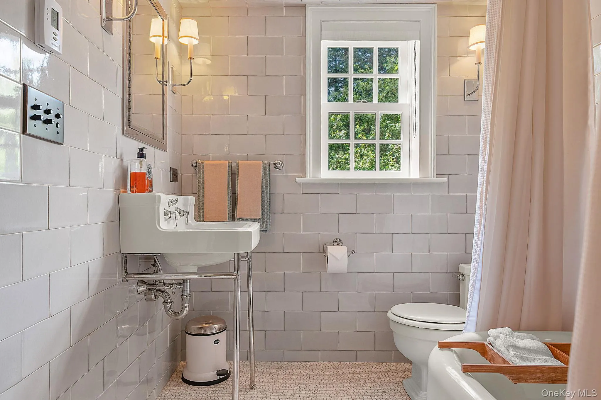 Full bathroom featuring tile walls, curtained shower, tile patterned flooring, and pet washing area Full bathroom featuring tile walls, curtained shower, tile patterned flooring, and pet washing area