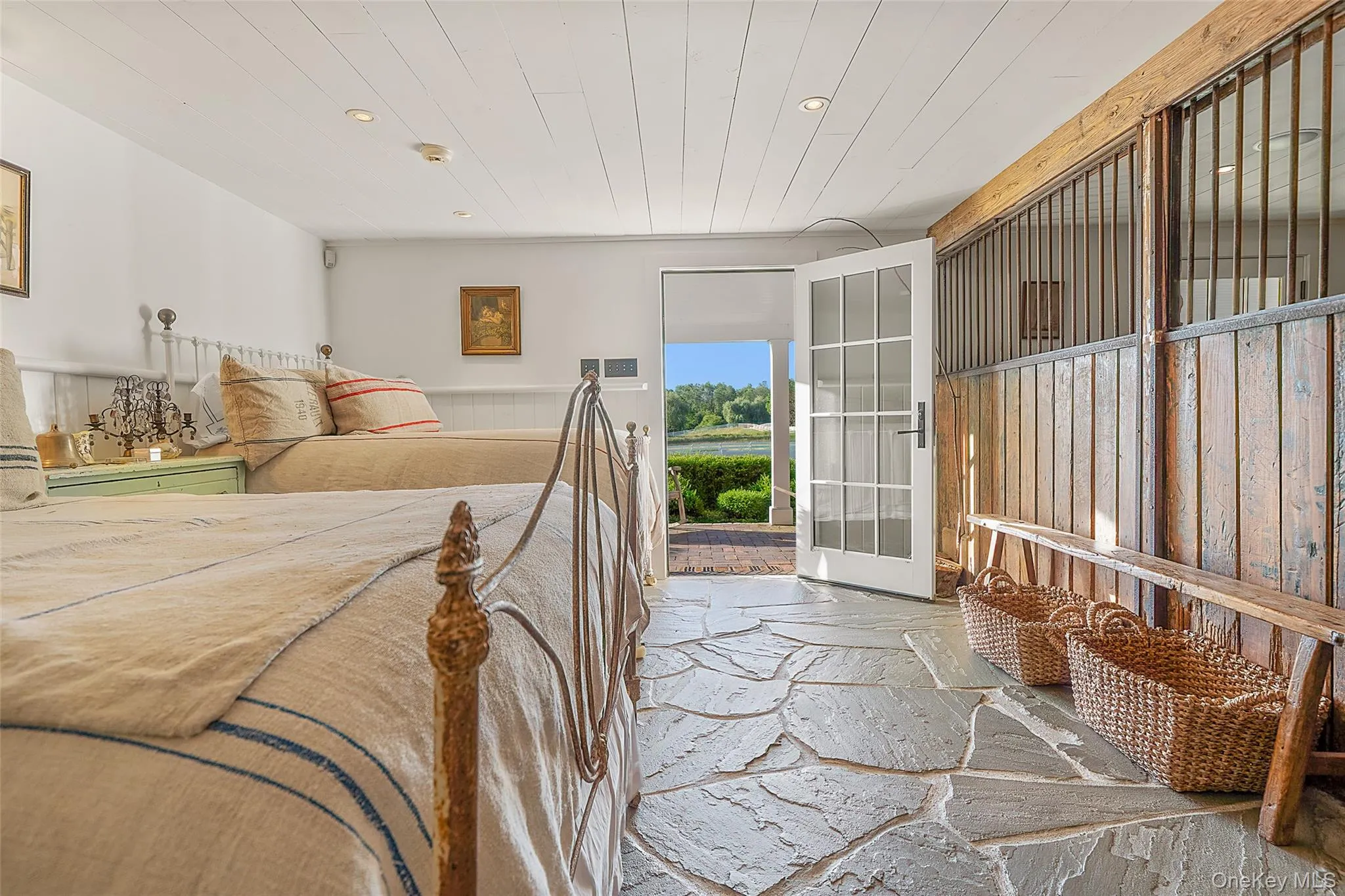 Bedroom with recessed lighting, stone flooring, wood ceiling, and a wainscoted wall Bedroom with recessed lighting, stone flooring, wood ceiling, and a wainscoted wall