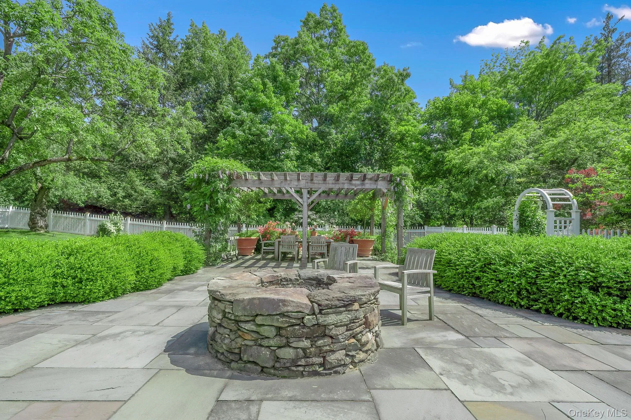 Fenced backyard with a patio area, a fire pit, and a pergola Fenced backyard with a patio area, a fire pit, and a pergola