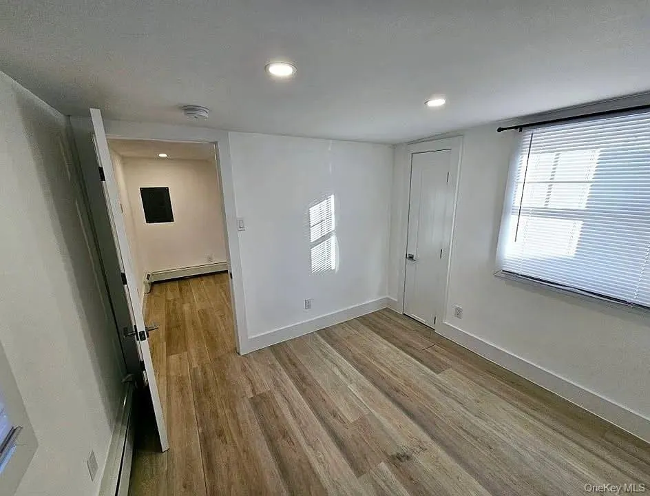 Spare room with light wood-style flooring, recessed lighting, and a baseboard radiator Spare room with light wood-style flooring, recessed lighting, and a baseboard radiator