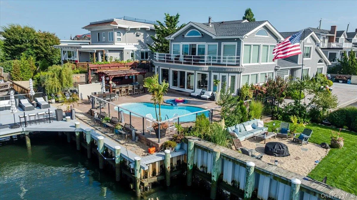 Back of property featuring a patio, an outdoor living space with a fire pit, a water view, and a pergola Back of property featuring a patio, an outdoor living space with a fire pit, a water view, and a pergola