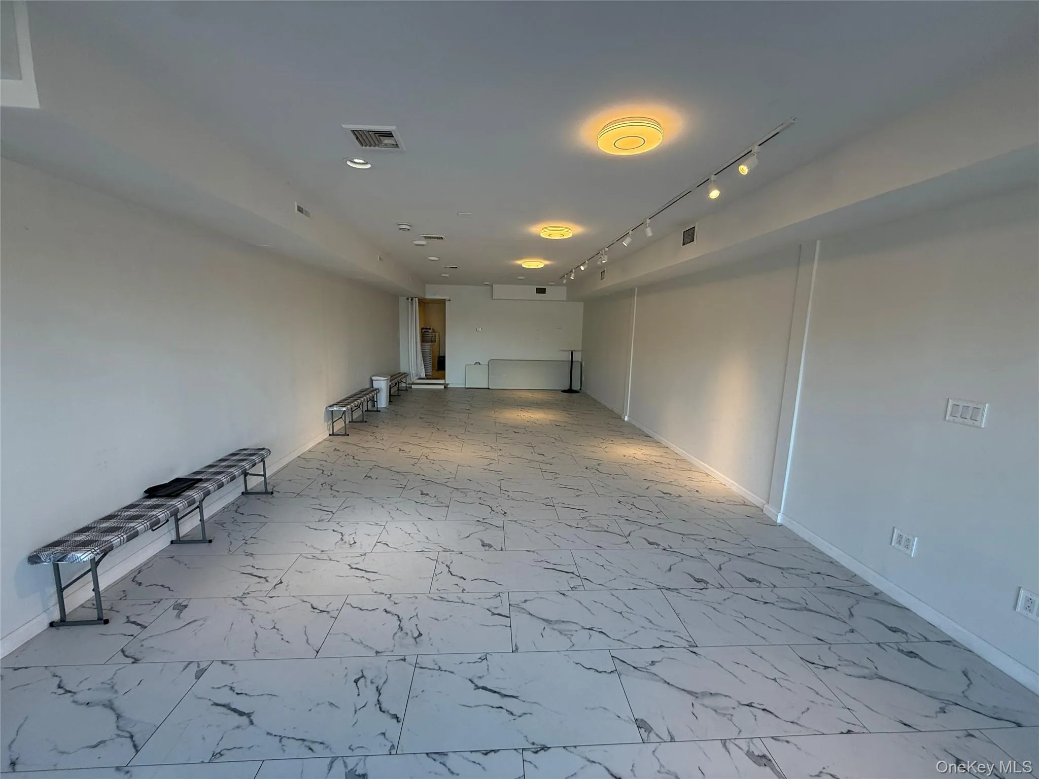 Unfurnished room with light marble finish flooring and track lighting Unfurnished room with light marble finish flooring and track lighting