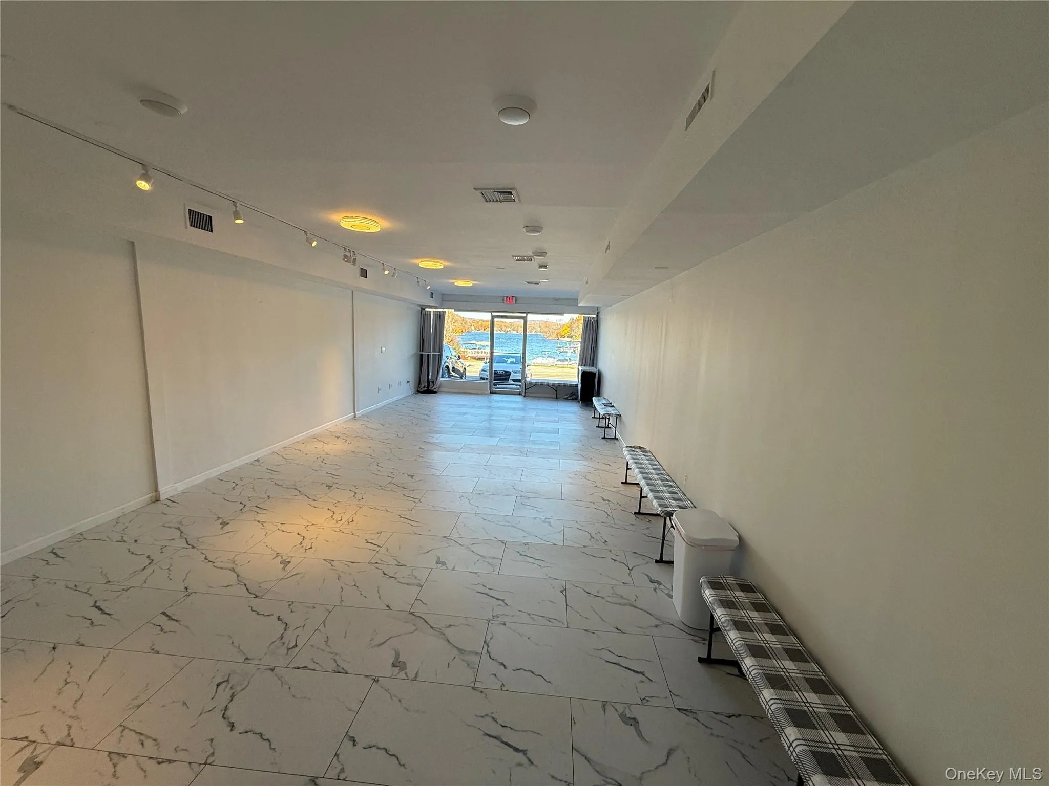 Hall with rail lighting and light marble finish flooring Hall with rail lighting and light marble finish flooring