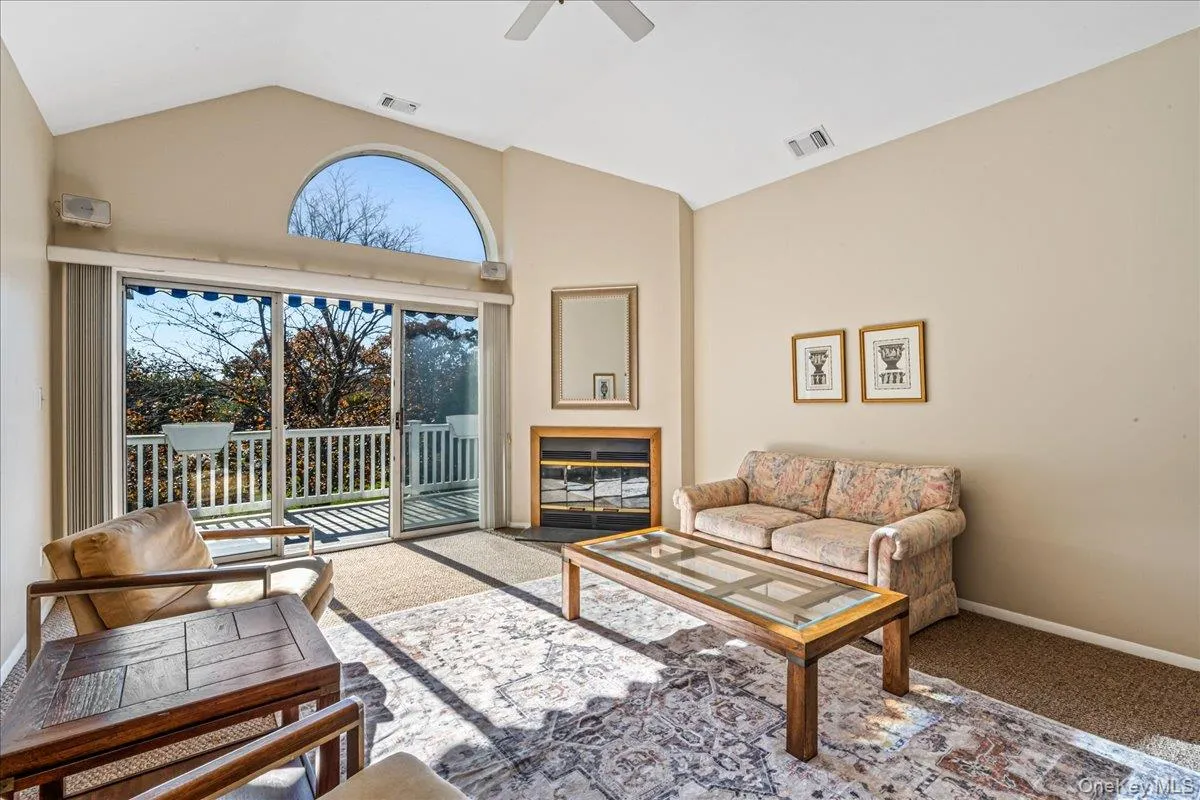 Living room featuring lofted ceiling, carpet floors, and a ceiling fan Living room featuring lofted ceiling, carpet floors, and a ceiling fan