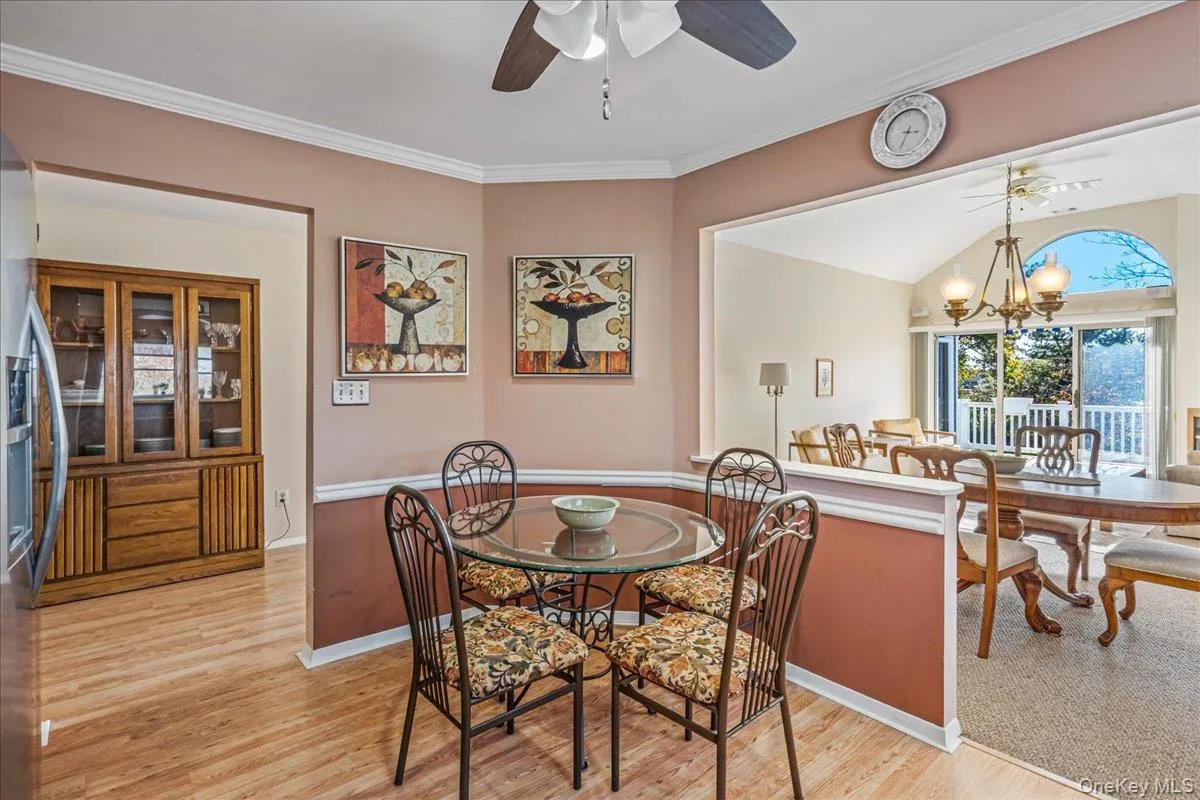 Dining area featuring crown molding, a chandelier, light wood-type flooring, and a ceiling fan Dining area featuring crown molding, a chandelier, light wood-type flooring, and a ceiling fan