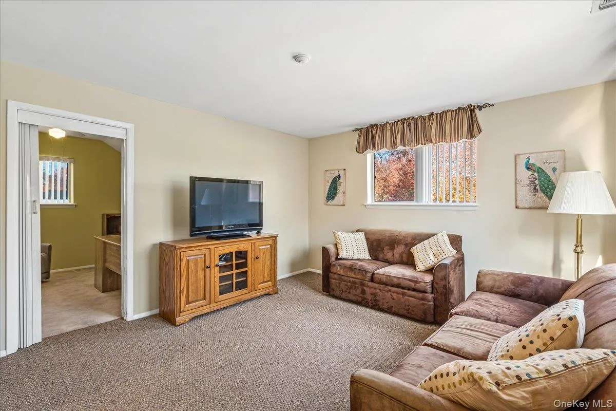 Carpeted living room featuring baseboards Carpeted living room featuring baseboards