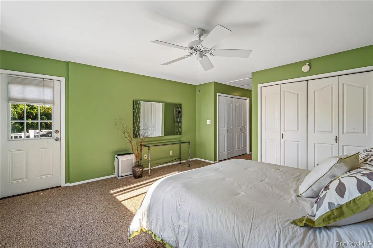 Carpeted bedroom featuring baseboards and ceiling fan Carpeted bedroom featuring baseboards and ceiling fan