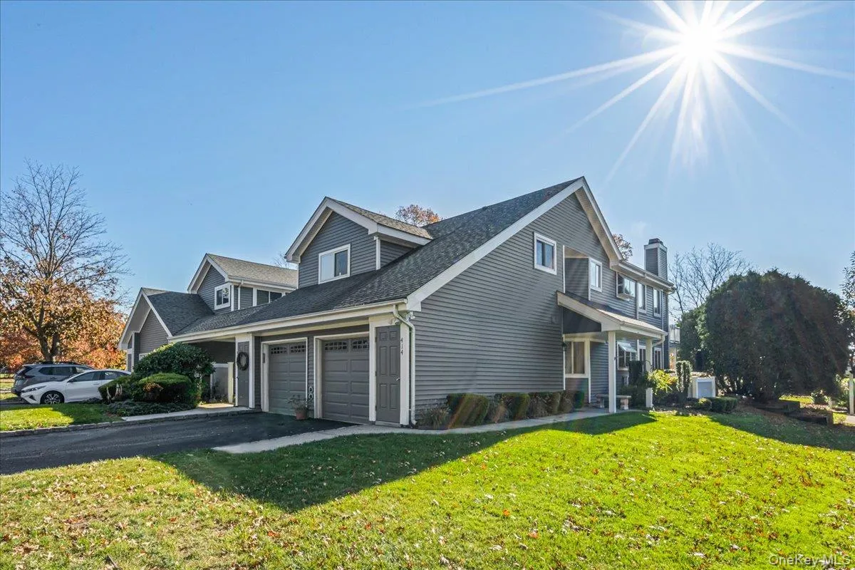 View of side of property featuring a yard, asphalt driveway, a shingled roof, and a garage View of side of property featuring a yard, asphalt driveway, a shingled roof, and a garage