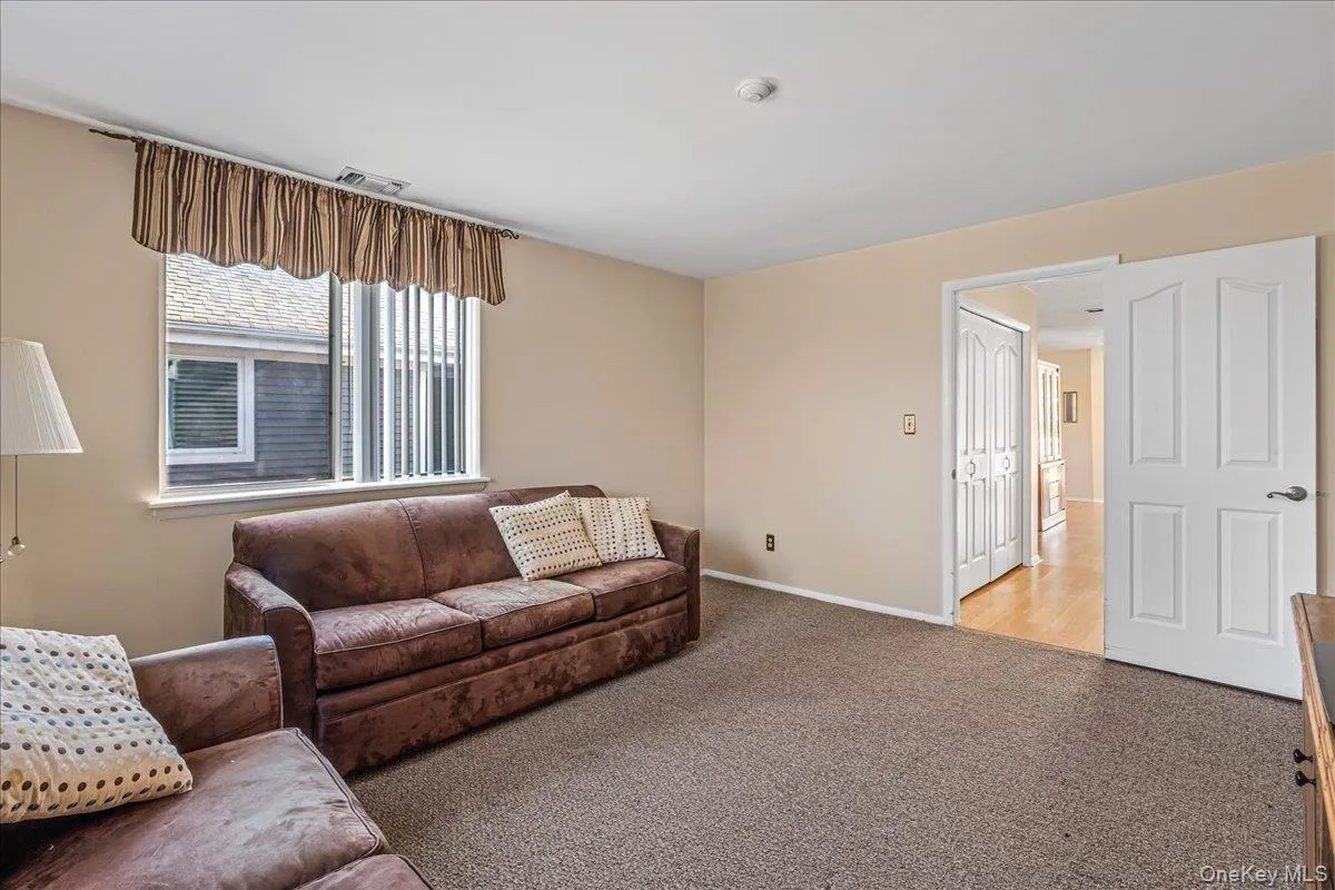 Living room featuring light carpet and baseboards Living room featuring light carpet and baseboards