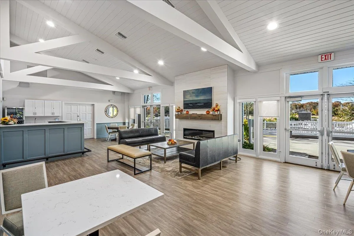 Living area featuring high vaulted ceiling, light wood-type flooring, a large fireplace, recessed lighting, and a wood ceiling with exposed beams Living area featuring high vaulted ceiling, light wood-type flooring, a large fireplace, recessed lighting, and a wood ceiling with exposed beams
