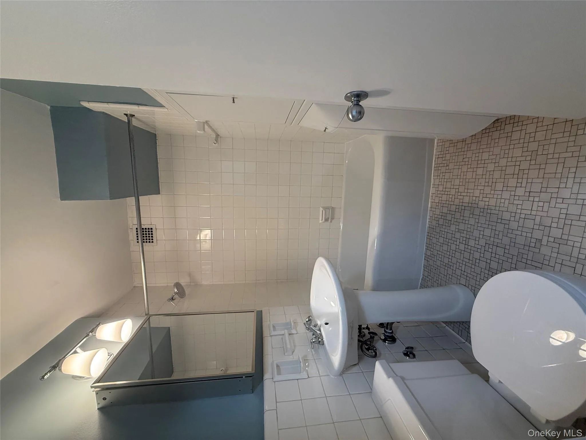 Bathroom with bathing tub / shower combination, tile walls, and light tile patterned floors Bathroom with bathing tub / shower combination, tile walls, and light tile patterned floors