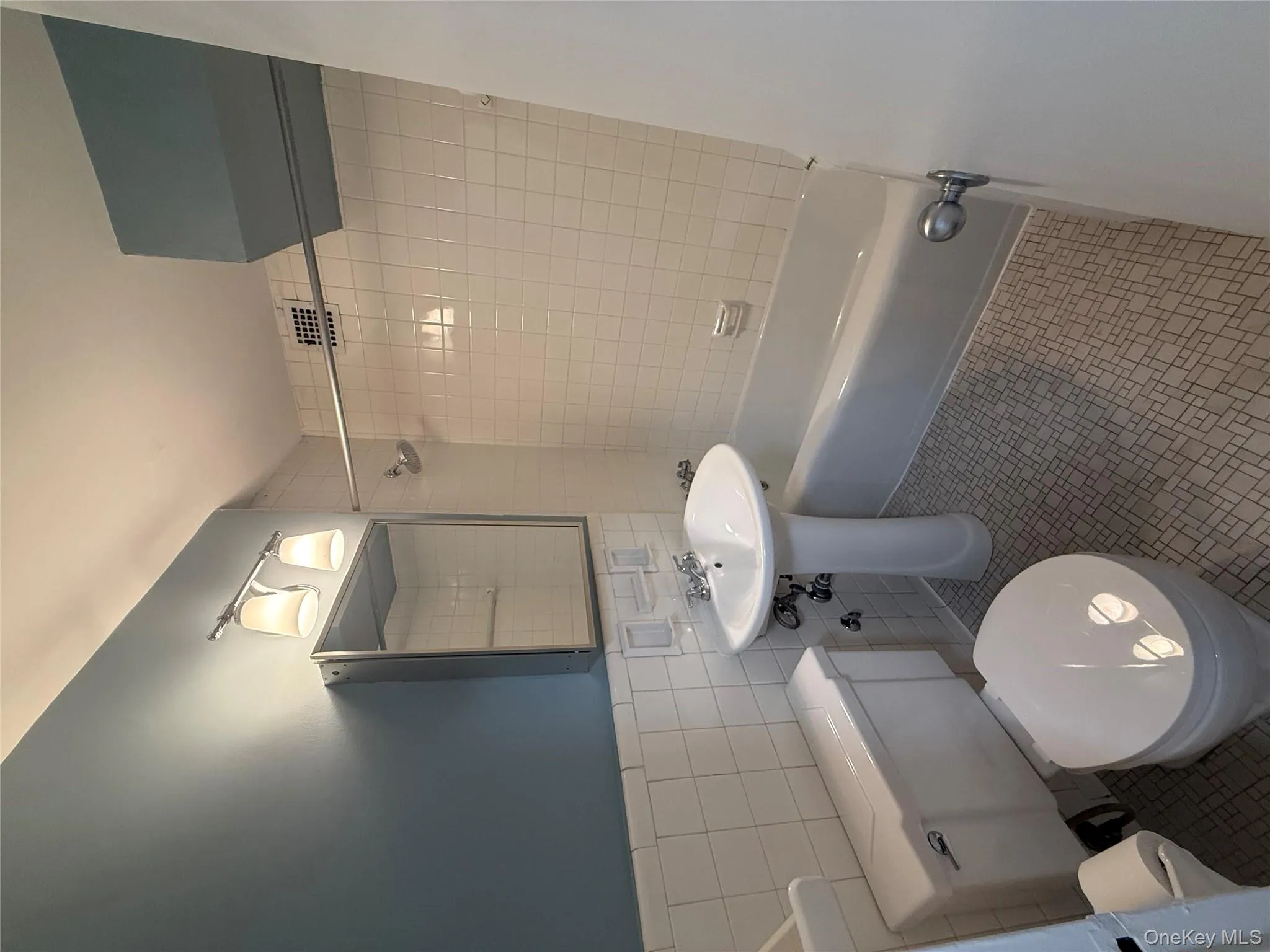 Full bathroom with tile walls, bathtub / shower combination, and tile patterned floors Full bathroom with tile walls, bathtub / shower combination, and tile patterned floors