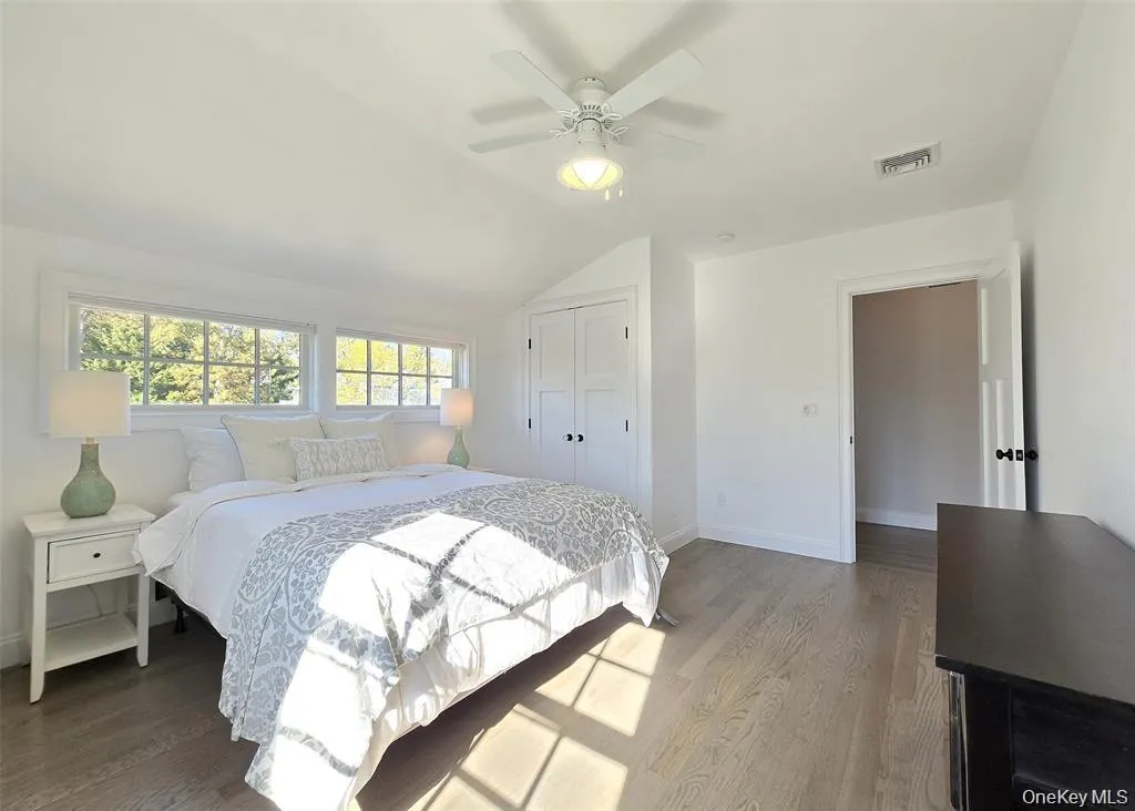 Bedroom featuring wood finished floors, vaulted ceiling, a closet, and ceiling fan Bedroom featuring wood finished floors, vaulted ceiling, a closet, and ceiling fan
