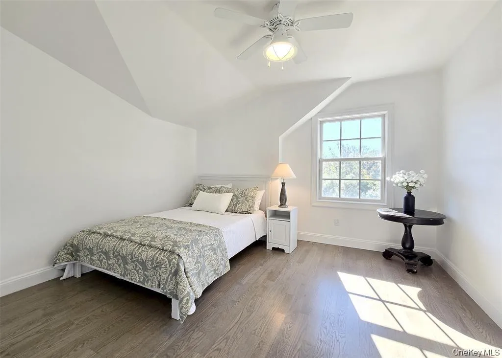 Bedroom featuring wood finished floors, ceiling fan, and vaulted ceiling Bedroom featuring wood finished floors, ceiling fan, and vaulted ceiling