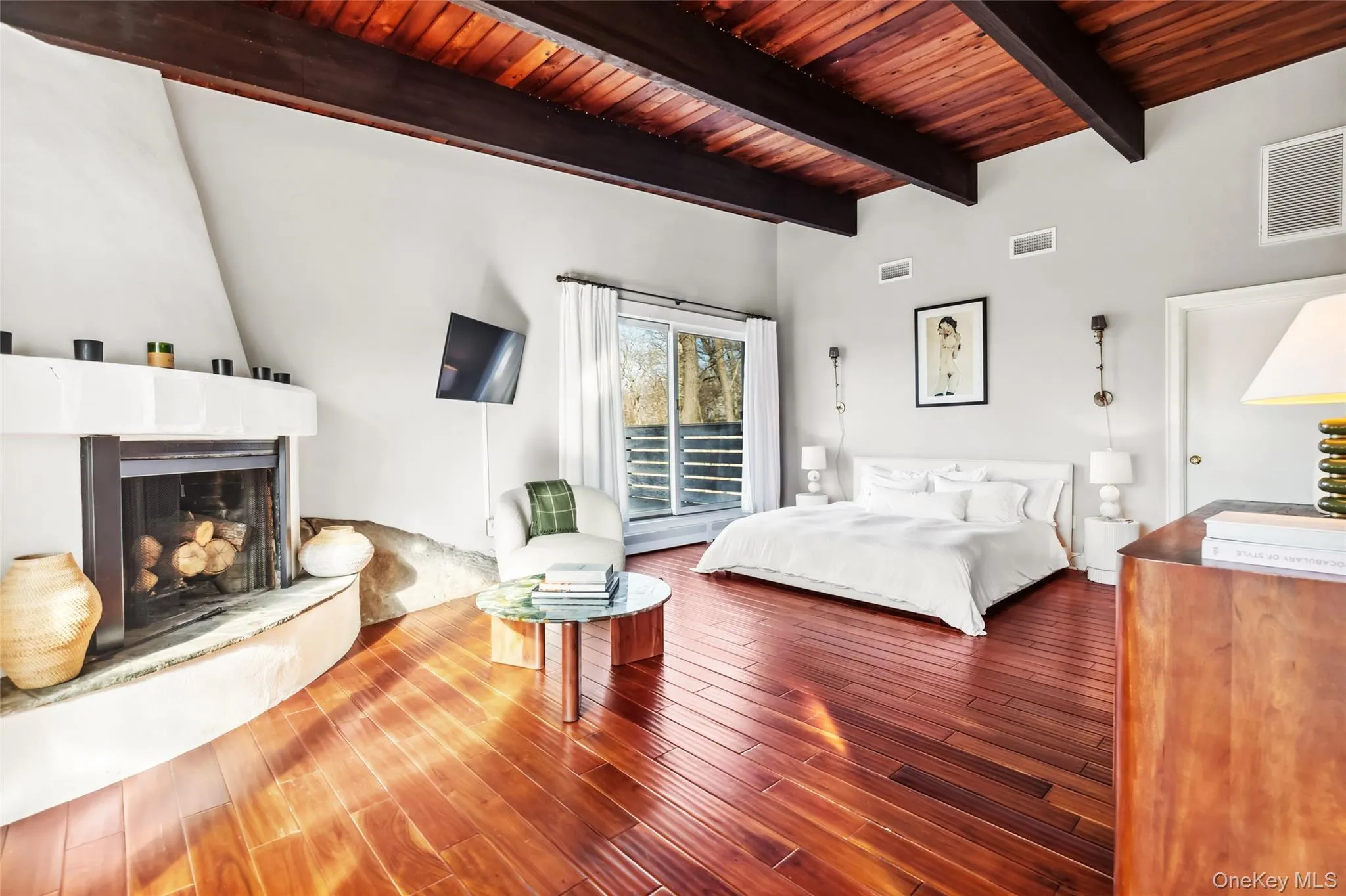 Bedroom featuring a fireplace, beamed ceiling, wooden ceiling, and hardwood / wood-style flooring Bedroom featuring a fireplace, beamed ceiling, wooden ceiling, and hardwood / wood-style flooring