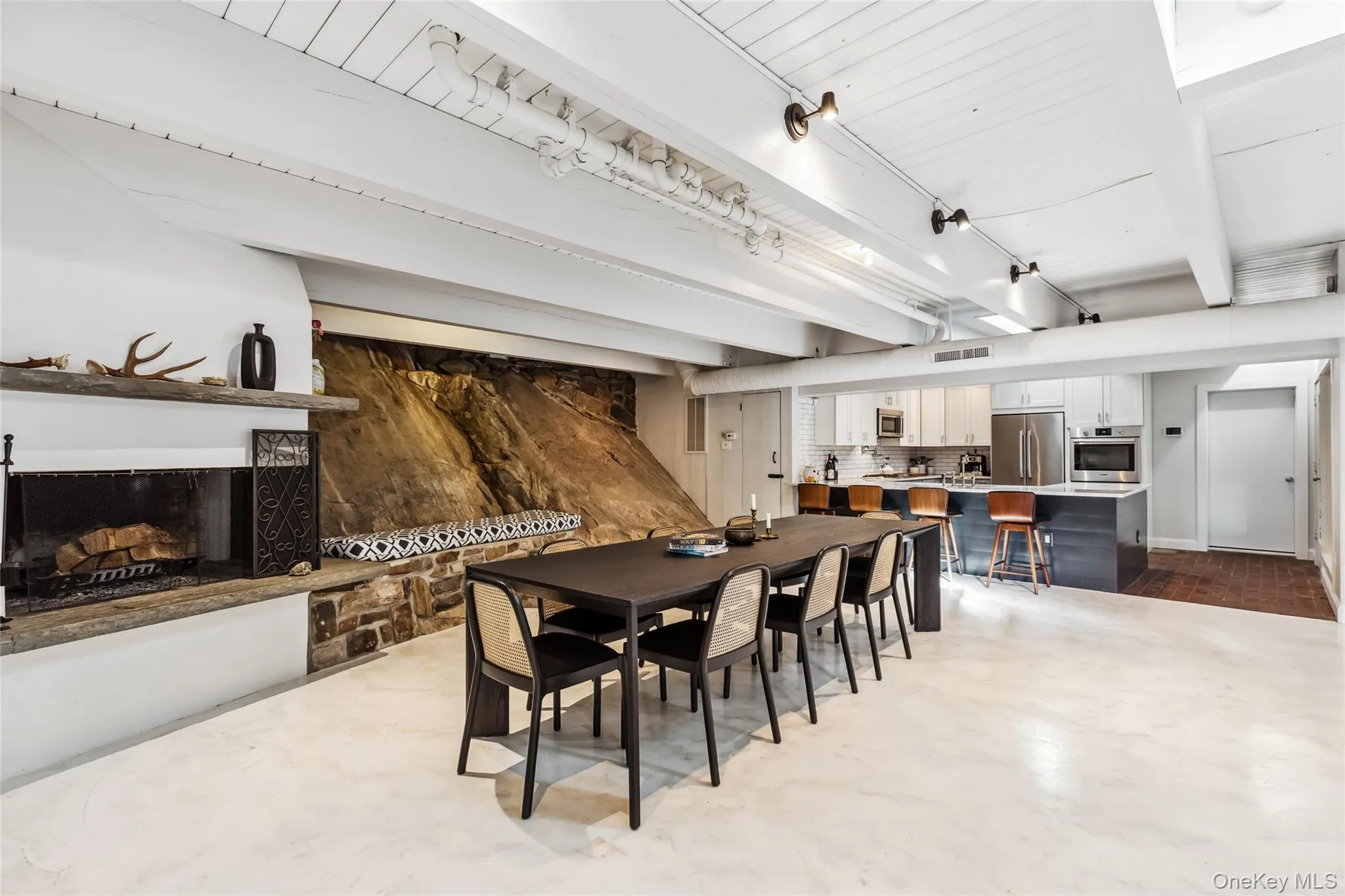 Dining area featuring beamed ceiling and concrete floors Dining area featuring beamed ceiling and concrete floors