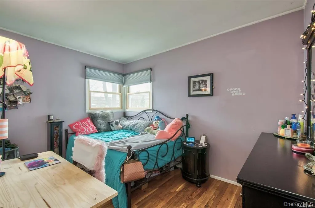 Bedroom with dark wood finished floors and baseboards Bedroom with dark wood finished floors and baseboards