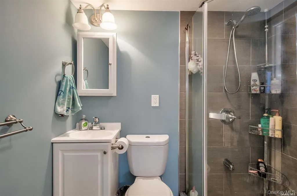 Full bathroom featuring a shower stall and vanity Full bathroom featuring a shower stall and vanity