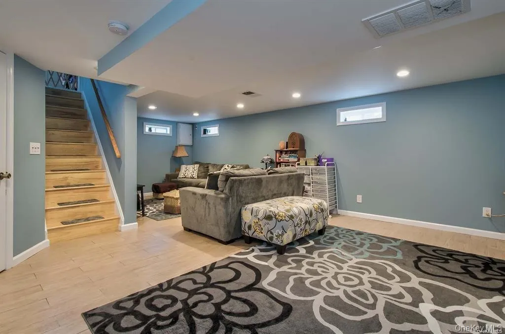Living area featuring light wood-style floors, recessed lighting, and stairway Living area featuring light wood-style floors, recessed lighting, and stairway
