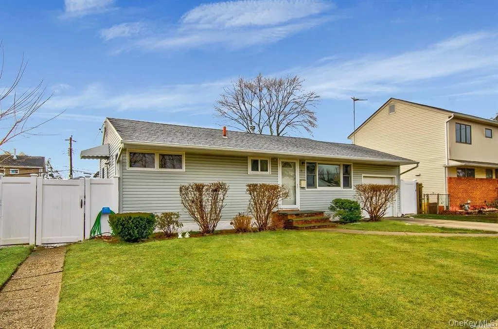 View of front of property featuring a shingled roof, a gate, and an attached garage View of front of property featuring a shingled roof, a gate, and an attached garage