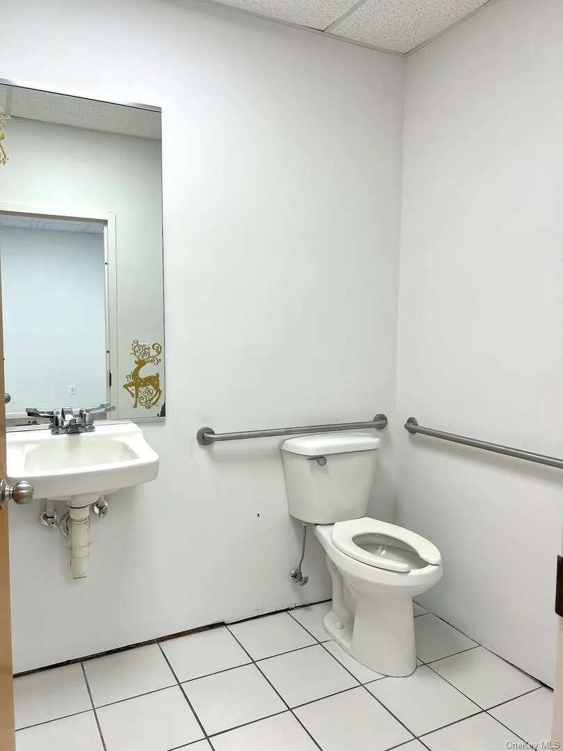 Half bath with light tile patterned floors and a paneled ceiling Half bath with light tile patterned floors and a paneled ceiling