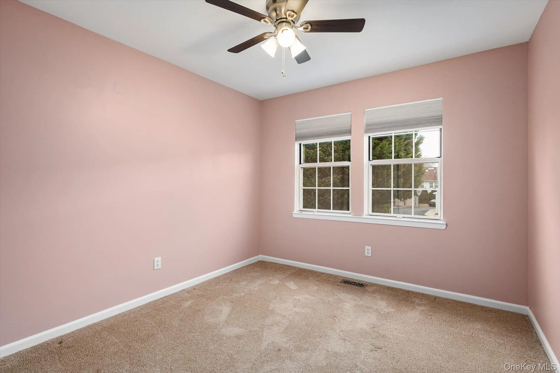 Carpeted spare room featuring baseboards and ceiling fan Carpeted spare room featuring baseboards and ceiling fan