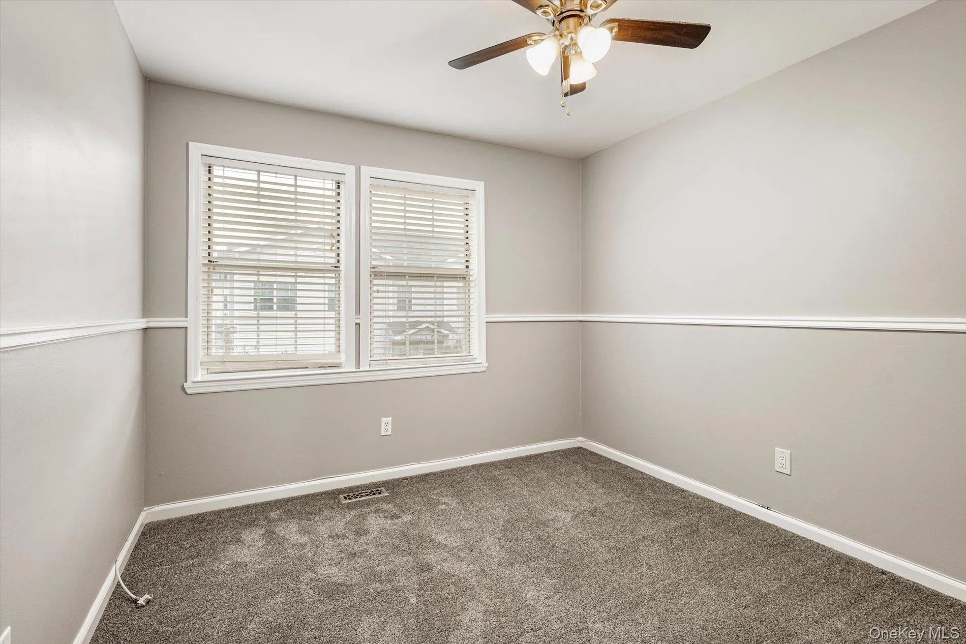 Carpeted spare room featuring baseboards and a ceiling fan Carpeted spare room featuring baseboards and a ceiling fan