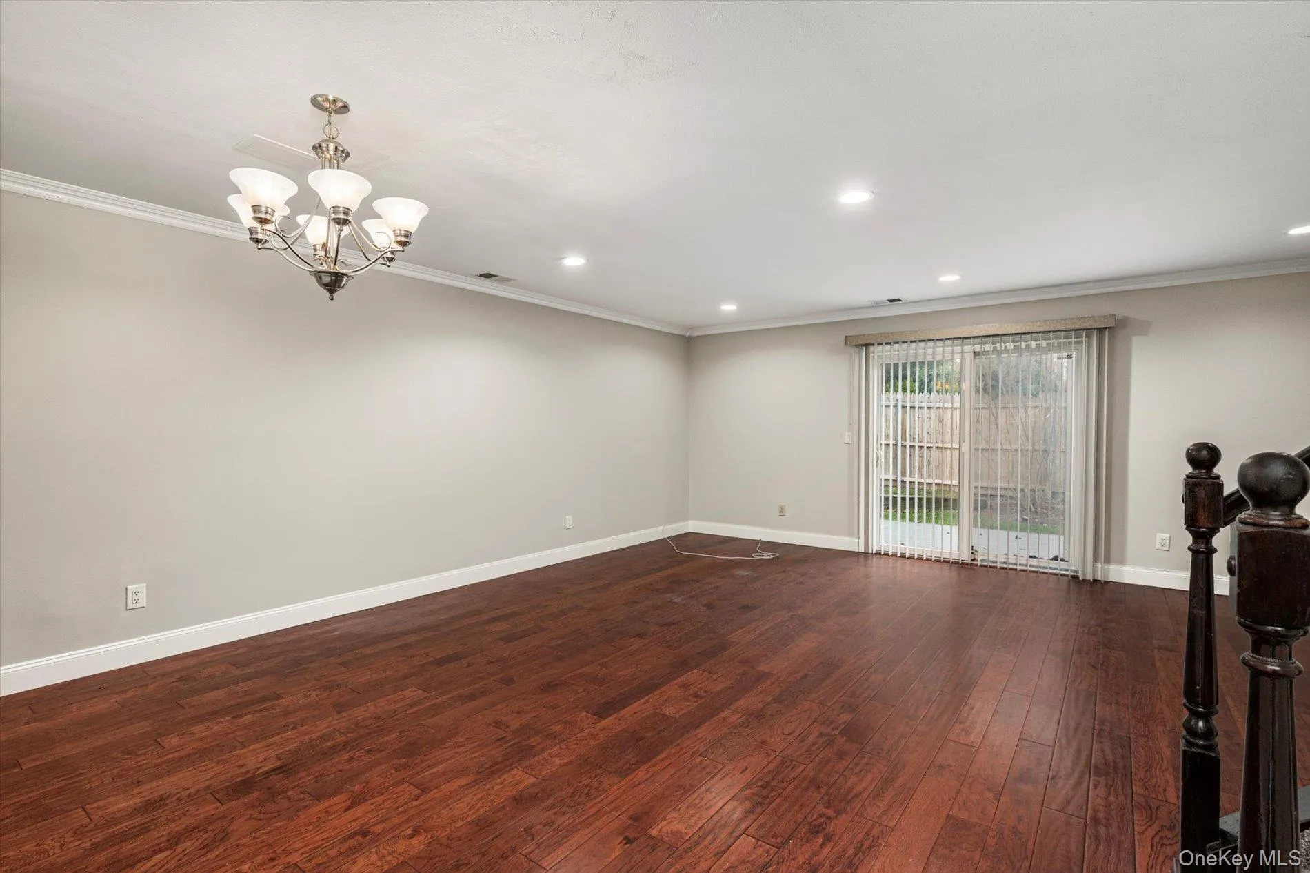 Spare room featuring dark wood-style floors, ornamental molding, a chandelier, and recessed lighting Spare room featuring dark wood-style floors, ornamental molding, a chandelier, and recessed lighting
