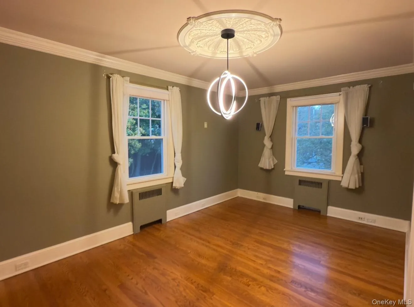 Bedroom 2 with ornamental molding, radiator, and dark wood-style flooring Bedroom 2 with ornamental molding, radiator, and dark wood-style flooring