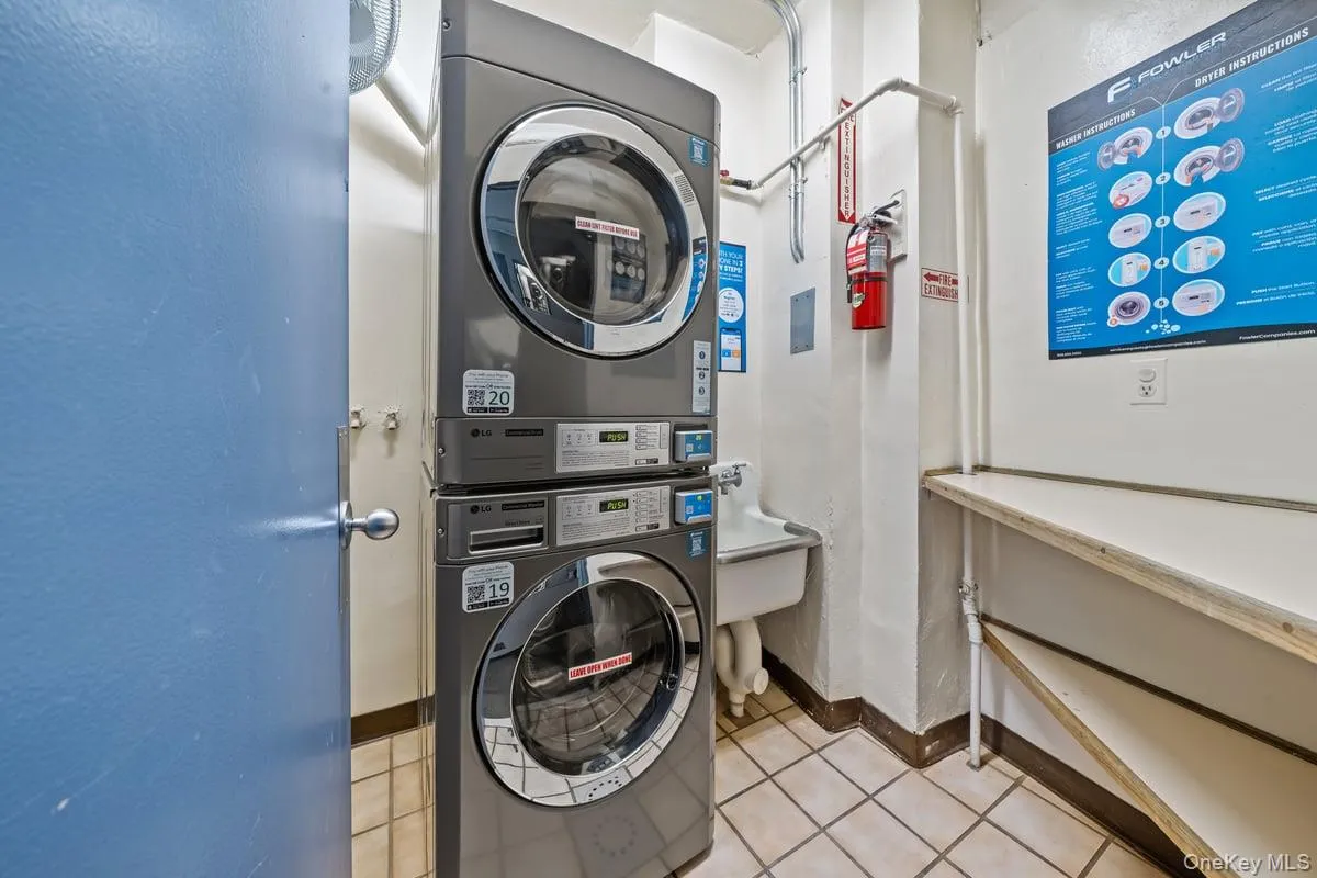 Washroom featuring estacked washer and dryer and a sink Washroom featuring estacked washer and dryer and a sink