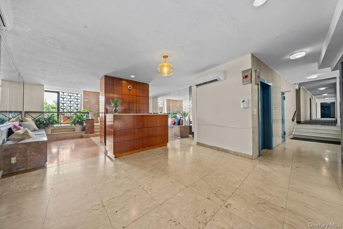 Reception area featuring expansive windows, a textured ceiling, and stairway Reception area featuring expansive windows, a textured ceiling, and stairway