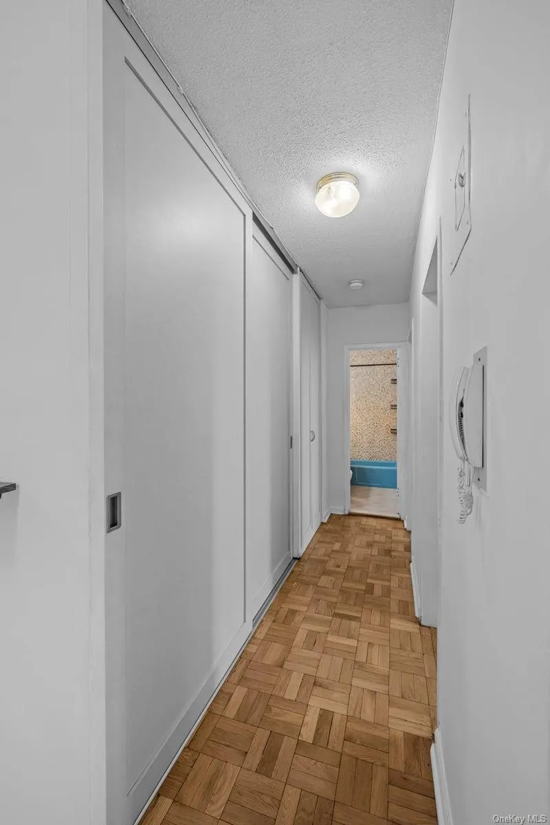 Corridor with a textured ceiling and baseboards Corridor with a textured ceiling and baseboards