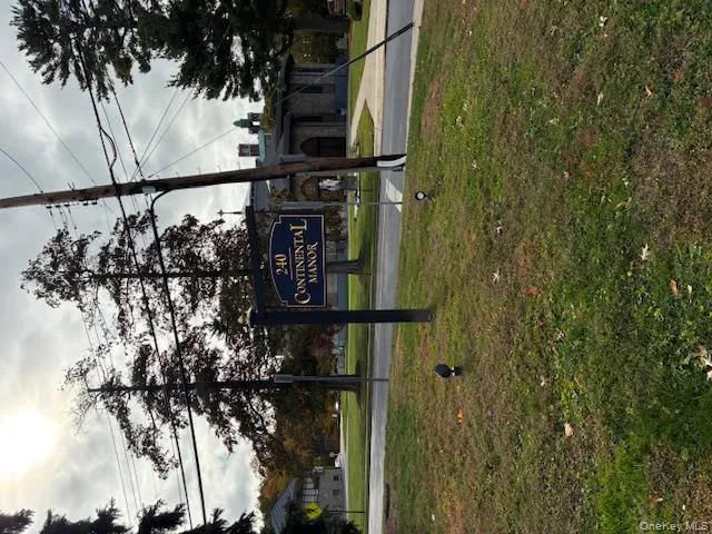 Community sign featuring a yard Community sign featuring a yard