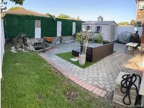 Fenced backyard featuring a patio and a storage unit Fenced backyard featuring a patio and a storage unit