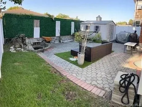 Fenced backyard with a patio and a storage unit Fenced backyard with a patio and a storage unit