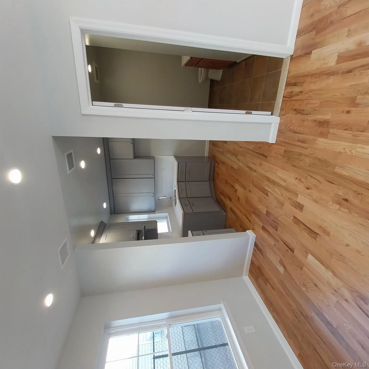 Kitchen with gray cabinetry, light countertops, recessed lighting, and light wood finished floors Kitchen with gray cabinetry, light countertops, recessed lighting, and light wood finished floors