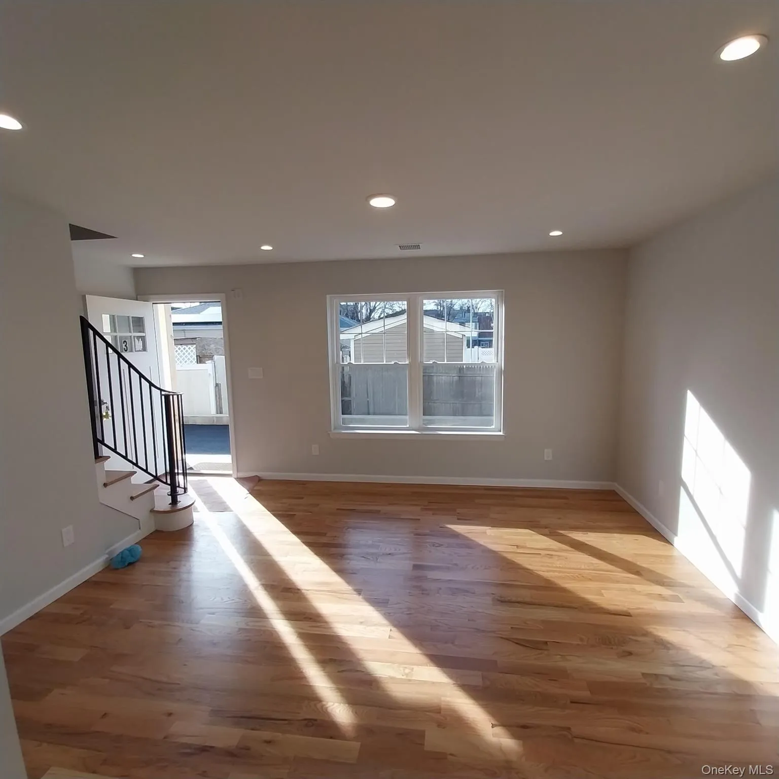 Unfurnished living room featuring stairs, light wood finished floors, healthy amount of natural light, and recessed lighting Unfurnished living room featuring stairs, light wood finished floors, healthy amount of natural light, and recessed lighting