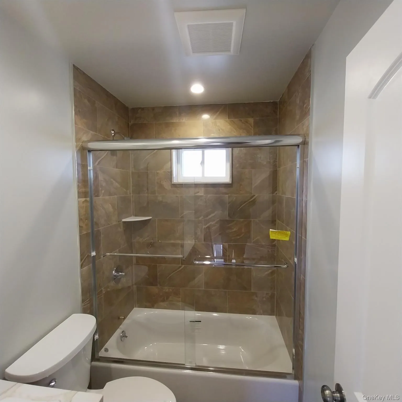 Full bathroom with toilet and enclosed tub / shower combo Full bathroom with toilet and enclosed tub / shower combo