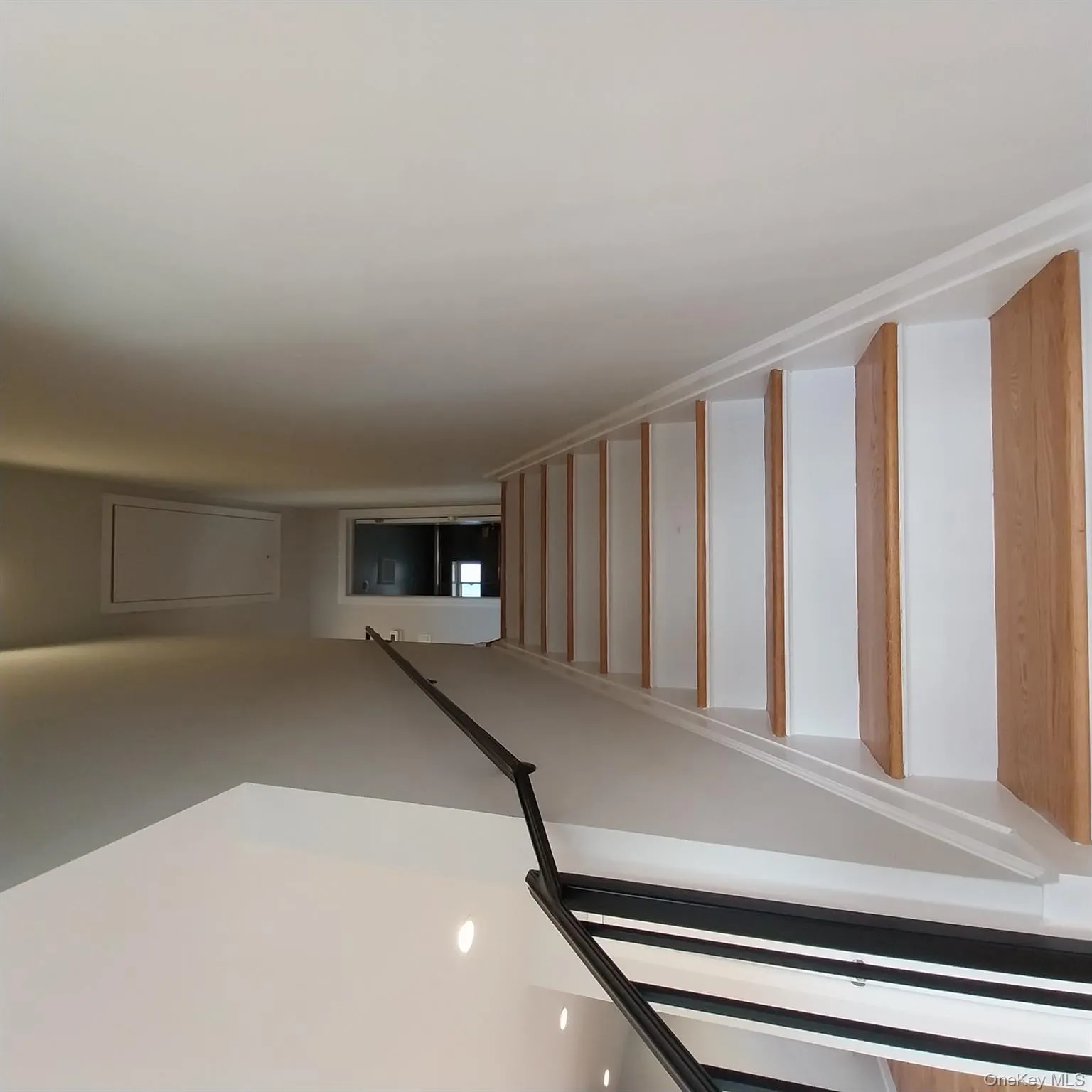 Stairway featuring attic access, recessed lighting, and wood finished floors Stairway featuring attic access, recessed lighting, and wood finished floors
